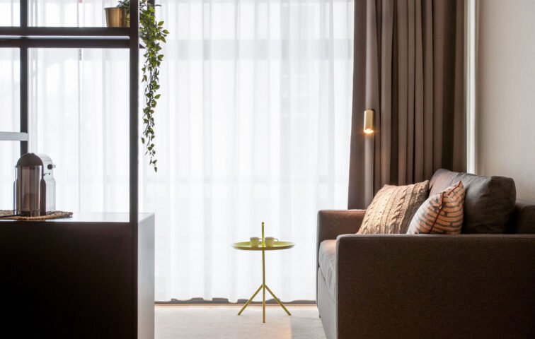 PREMIER SUITES Antwerp - Deluxe room sitting area pullout sofabed